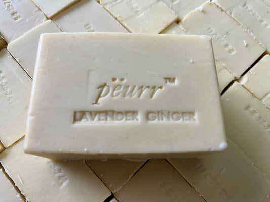 Bar of olive oil and goat milk soap with the brand peurr and the scent of lavender and ginger engraved on it