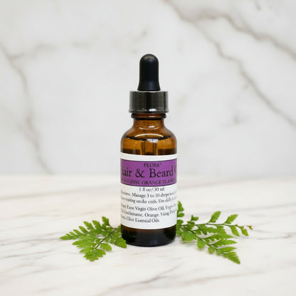 Bottle of hair and beard oil with a dropper on a white background
