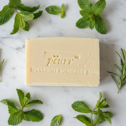 Bar of soap with 'peurr' branding surrounded by fresh mint leaves on a marble surface