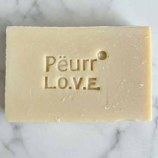 Bar of soap with Peurr L.O.V.E. branding on a marble surface