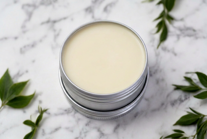 Open silver tin of PËURR® Unscented Body Butter showing its smooth cream-colored surface on white marble.