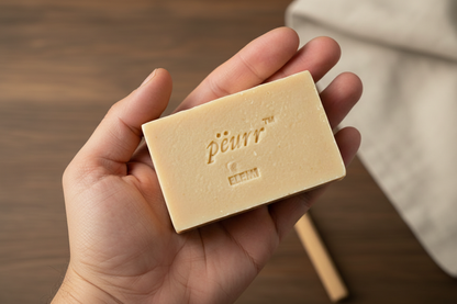 PËURR® Elemi Olive Oil & Goat Milk Soap held naturally in a hand