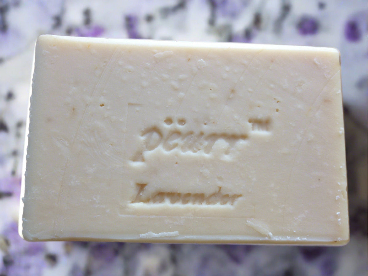 A bar of lavender goat milk and olive oil soap with the brand name 'PÈURR®' stamped on the top.