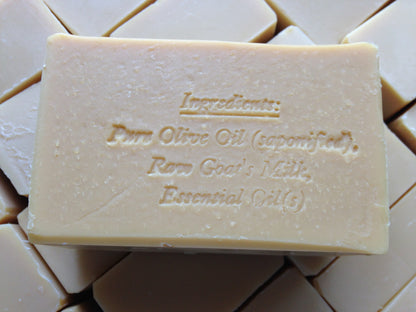 A bar of beige soap with the ingredients engraved on it.
