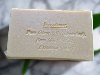 A bar of beige soap with the ingredients engraved on it.