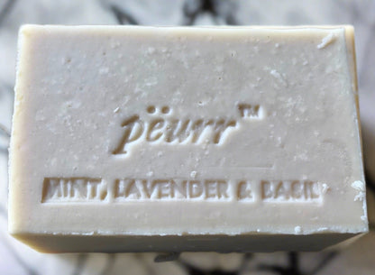 A bar of soap with 'Péurr' branded on the top, along with the words 'Peppermint, Lavender & Basil'.