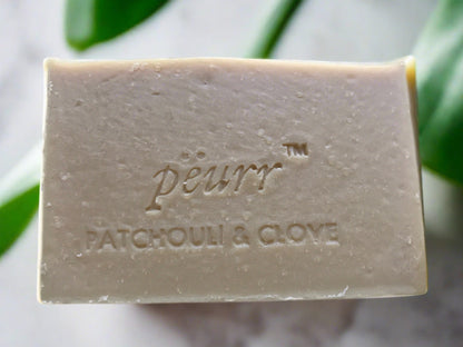 A bar of Patchouli & Clove soap with the brand name 'PÉURR®' embossed on the top.
